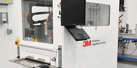 Image of a gantry system with an entry slot and two windows for process visibility
