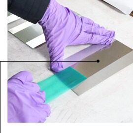 Image of gloved hands removing 3M™ Polyester Tape 8992, leaving sharp masked lines and no residue