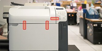 A printer with red tapes indicating the usage of glue/tape to be sealed in place for parts security
