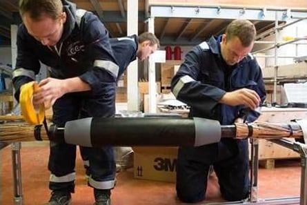 Two electricians repair multi-conductor cable