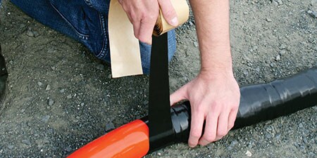 Worker wrapping power cable with 3M Heavy Duty Mining Tape
