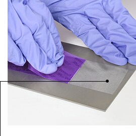 Image of gloved hands removing 3M™ Anodizing Masking Tape 8985L, leaving sharp masked lines and no residue