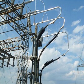 High voltage terminations and high voltage wires against blue sky and clouds