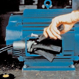 Compartment of motor housing revealing electrical motor leads. Hand is pulling on rubber wrap.