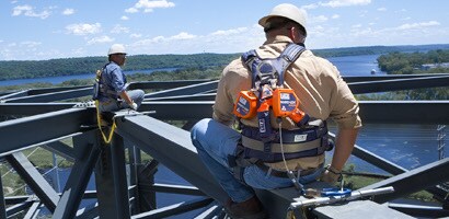 Workers on top of bridge beams secured by all protection gear
