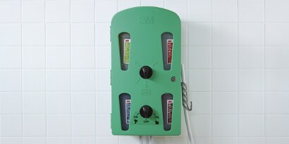 3M™ Flow Control Chemical Management System, in green plastic and mounted on a wall.
