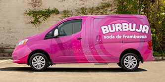 Pink delivery van displaying a full color change and print wrap installation.
