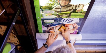 man installing promotional graphics on storefront windows to enhance store experience
