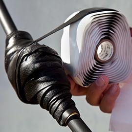 Image of 3M™ Scotch-Seal™ Mastic Sealing Tape 2229 wrapping around a low voltage cable with sealing connector covered with Scotch® 2510 Varnish Cambric Tape.