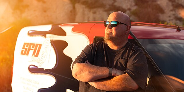 John Sticky Fingers Meehan Founder of SFDS leaning against a car wrapped with IJ280

