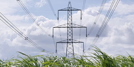 image of power transmission tower in field
