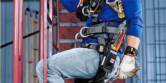Worker at height with tools secured with pouch and tether
