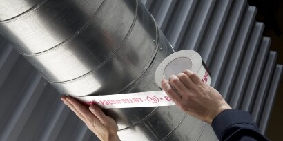 Worker applying Scotch Foil Tape 3326 to an HVAC duct

