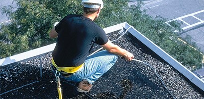 Worker on roof wearing restraint belt
