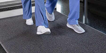 two people walking on 3M floor matting in a hospital.
