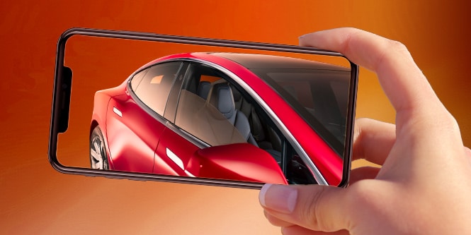 A hand holding a cell phone with a picture of a red car
