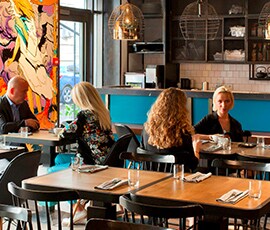 Four diners sitting in an inviting, clean restaurant.