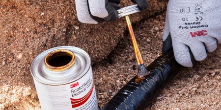 worker placing 3M Electrical FD coating on wire splice
