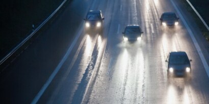 Cars on a wet road with headlights on
