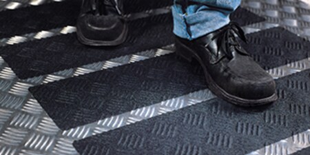 Someone walking on 3M Safety-Walk Slip-Resistant Tapes and Treads applied to a floor
