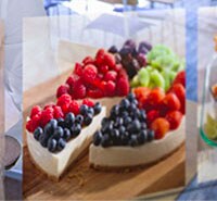An image of a fruit tart dessert is projected near a restaurant customer at a table.